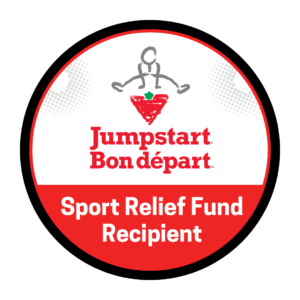 The Canadian Tire Jumpstart Charities badge: A circle with the silhouette of a person jumping on the Canadian Tire logo. The Canadian Tire logo is an upside-down triangle with a green maple leaf on the top centre of the triangle. Below the Canadian Tire logo is the words 'Jumpstart Bon Départ' in red letters. Below this it says 'Sport Relief Fund Recipient' in white letters on a red background.