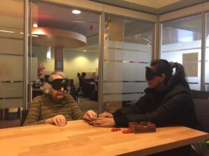 PTCB student, Kashmere, teaching the basic concept of Braille to Anne using a peg board.